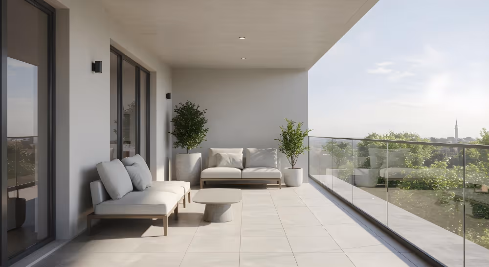 Varanda moderna com sofá branco, mesa baixa e plantas em vasos, com vista para árvores e céu claro.